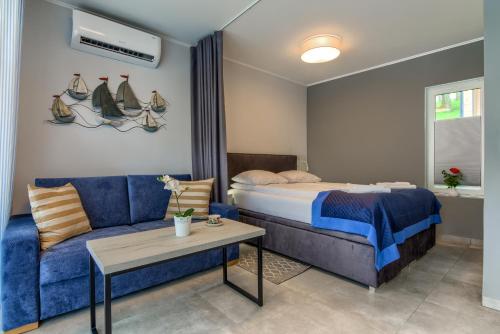 米科瓦伊基Enklawa Mikołajki的一间卧室配有一张床和一张蓝色的沙发