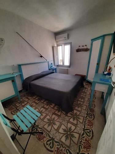 滨海波利尼亚诺卡塞塔佩斯卡托旅馆的一间卧室配有一张床和一张蓝色椅子