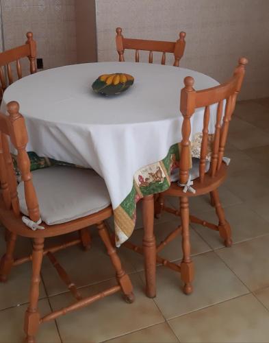 圣洛伦索Apartamento no centro的一张带两把椅子的白色桌子和一碗水果