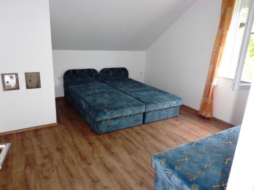 福纽德Traumblick Appartement am Balaton的一间卧室配有一张床和一个蓝色的搁脚凳