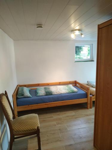 GönnernFerienwohnung Angelburg - Marburg Biedenkopf mit Terrasse的一间卧室,卧室内配有一张床和一把椅子