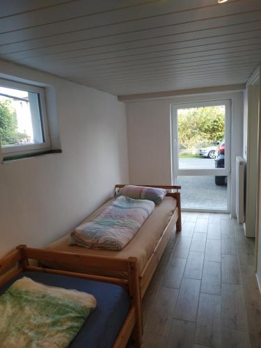 GönnernFerienwohnung Angelburg - Marburg Biedenkopf mit Terrasse的一间卧室设有两张床和窗户。
