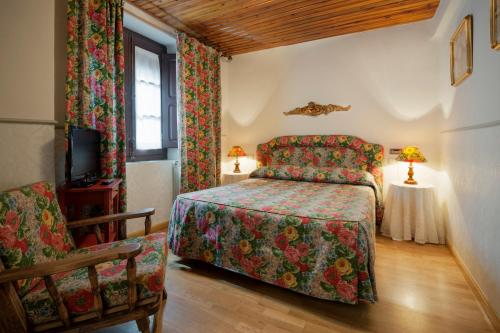 埃乔Hostal Casa Blasquico - Restaurante Gaby的一间卧室配有一张床和一把椅子