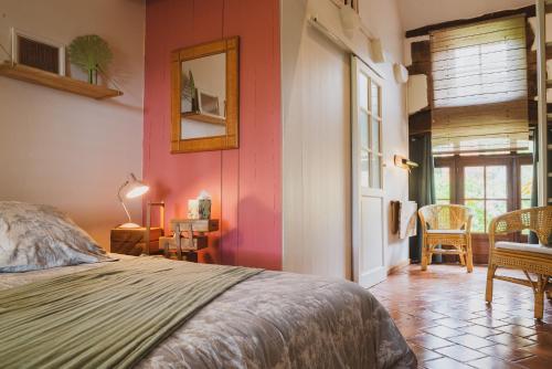 科隆热La douce France的卧室设有粉红色的墙壁、一张床和一张桌子