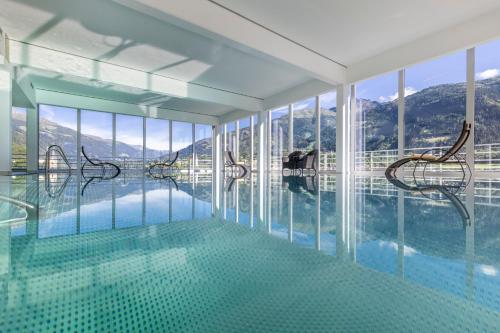 利恩茨沃吉内尔特劳贝酒店的一个带椅子的游泳池,位于窗户的房间