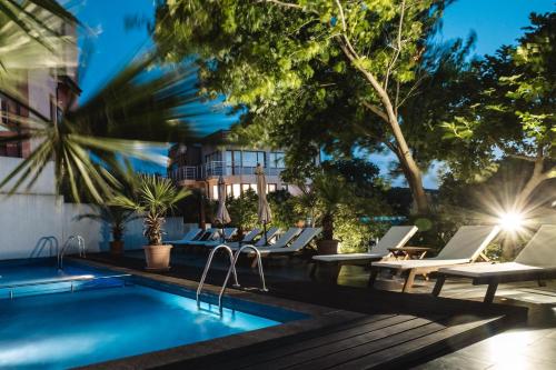 索佐波尔洛伽特洛设计酒店的一座带躺椅的游泳池位于大楼旁