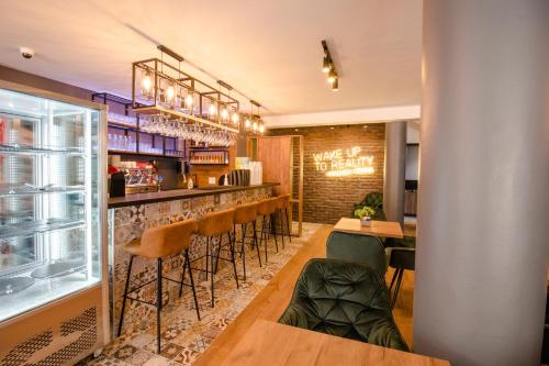 盖夫盖利亚OASIS Apartments的餐厅设有带凳子的酒吧