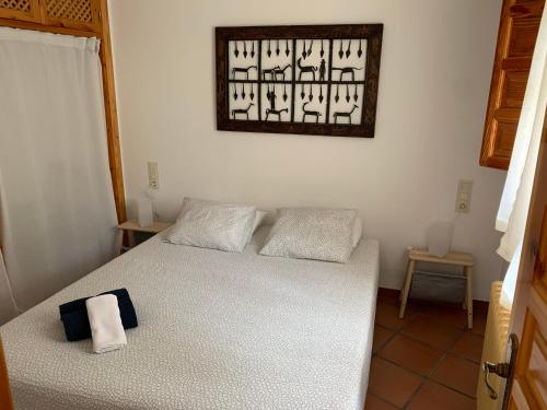 布维翁Acogedor Apartamento - La Alpujarra的一间卧室配有一张带白色床罩的床