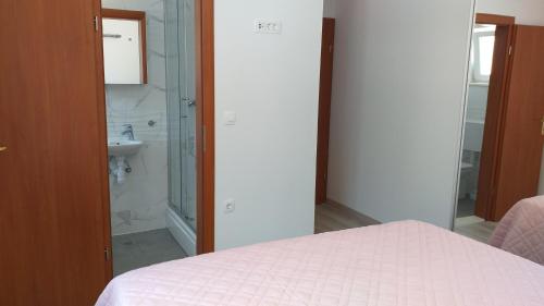 拉斯托伏APARTMAN KARLA的一间卧室配有一张床、淋浴和盥洗盆