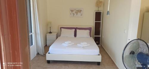 AnapaftíriaEfi Loutses的卧室配有白色的床和风扇