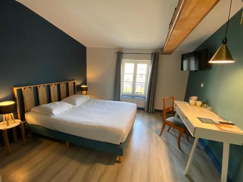 卡斯特尔Le Miredames Hôtel-Bar的一间卧室配有一张床、一张桌子和一张桌子