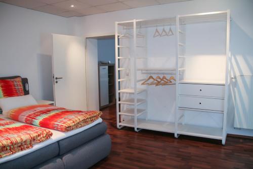 维岑豪森Premium Ferienwohnung Südsonne的卧室配有一张床和一个白色衣柜