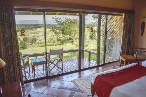 纳库鲁纳库鲁湖山林小屋的客房设有一张床和一个美景阳台