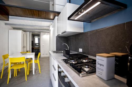 圣维托罗卡波Acquarò Suite Apartments的厨房配有炉灶和黄色椅子