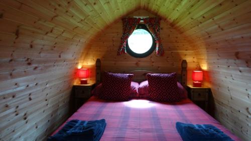 毕晓普斯堡Woodbatch Camping & Glamping的小木屋内一间卧室,配有一张床