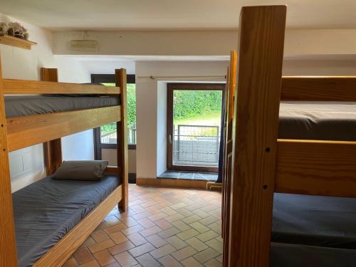 希尼Gîte La Semois的客房设有三张双层床和一扇窗户。