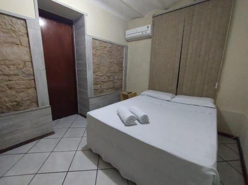 圣安娜-利弗拉门图Hotel Castelo的卧室配有白色床和毛巾