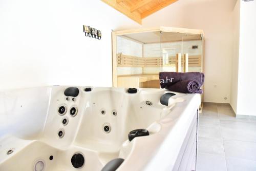扎达尔Villa Lux Nina with six bedrooms, private pool, sauna的浴室配有浴缸及镜子