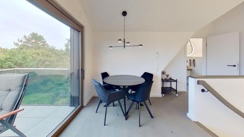 诺德奈Haus Kleemann K4的厨房以及带桌椅的用餐室。