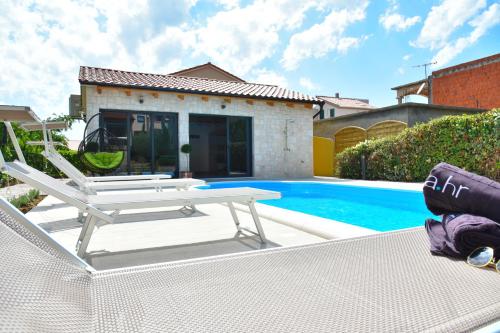 扎达尔Villa Lux Nina with six bedrooms, private pool, sauna的别墅 - 带游泳池和桌椅