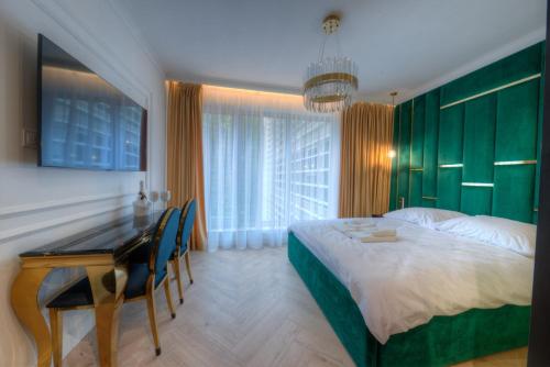 斯维诺乌伊希切Luxury Del Sol Apartments Świnoujście的一间卧室配有一张床、一张桌子和一张桌子