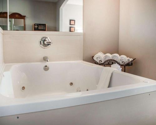 韦瑟福德韦瑟福德康福特茵酒店的浴室设有白色浴缸,配有毛巾