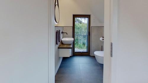 诺德奈Haus Kleemann K4的一间带两个盥洗盆、浴缸和卫生间的浴室