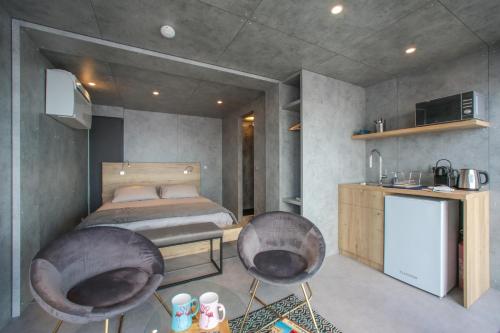 艾格-莫尔特Cabane CASSIOPEE Aigues- Mortes的一间卧室配有一张床和两把椅子