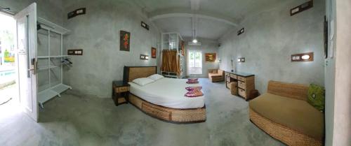 金巴兰Bali Bobo Hostel的一间大卧室,配有一张床和一张沙发