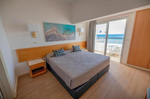 下皮尔戈斯提洛斯海滩酒店的一间卧室配有一张床,享有海景