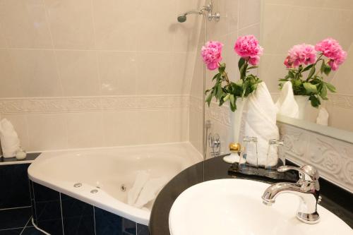 奎德林堡马克伽芬城堡酒店的浴室设有水槽和粉红色花卉浴缸。