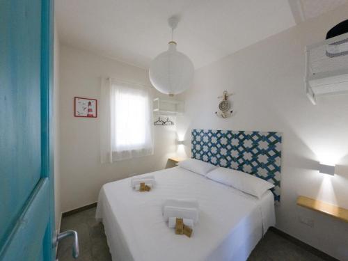 法维尼亚纳Albarìa Favignana Apartments的一间卧室配有一张白色的床和蓝色床头板