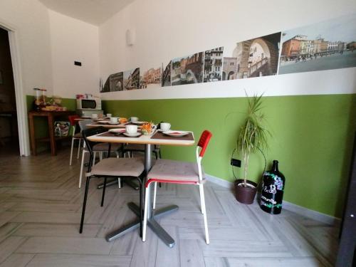 维罗纳阿莫尼亚住宿加早餐旅馆的绿墙客房内的桌椅