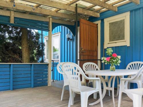玛丽斯塔德6 person holiday home in MARIESTAD的蓝色的房子,甲板上配有桌椅