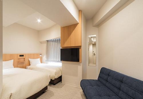 东京Hotel Mid In Kuramae Ekimae No Smoking Only的酒店客房,设有两张床和一张沙发