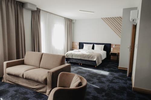 SkórczMolto Bene Hotel & Restaurant的酒店客房,配有床和沙发