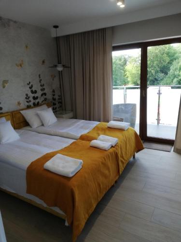 贡斯基Apartament Latarnik- Yellow的酒店客房,配有两张带毛巾的床
