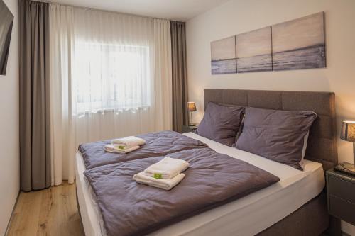 格拉茨Deluxe Apartment Graz的一间卧室配有一张床,上面有两条毛巾