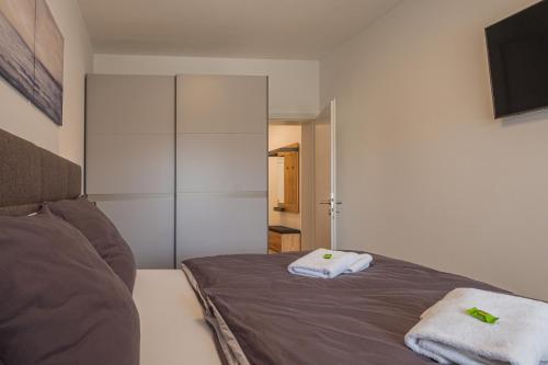格拉茨Deluxe Apartment Graz的一间卧室配有一张床,上面有两条毛巾