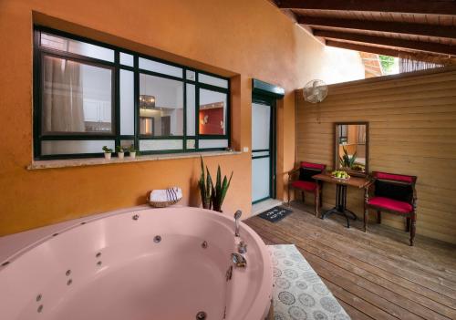 贝特莱切姆哈格利利特Zimmer & Spa Kesem Hamaga的大型浴室设有大浴缸和桌子