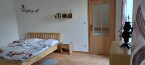OndřejovApartmán v Ladově kraji的卧室配有带白色床单的床和门。