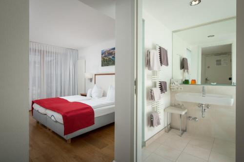 罗孚尔丹科乐餐厅酒店的一间卧室配有一张床,浴室设有水槽