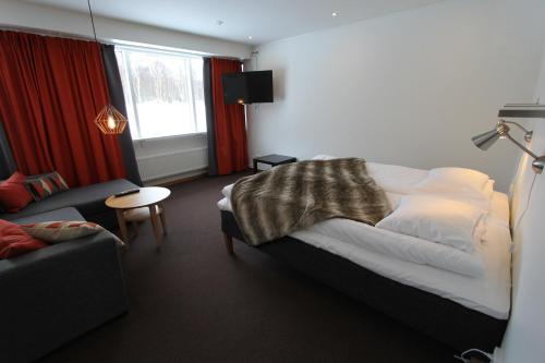 赫马万山区中心STF赫玛万斯酒店的一间卧室配有一张床、一张沙发和一个窗口