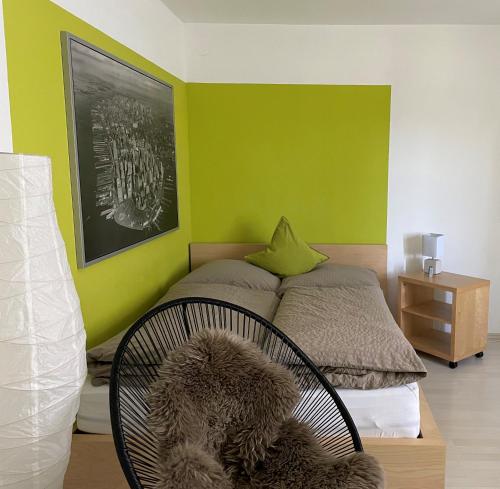 PfalzgrafenweilerBlack Forest Guest Stay的一间卧室配有一张带绿色墙壁的床和一把椅子