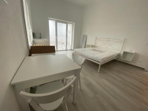 瓦里格提VILLA IRMA的客房设有一张床、一张桌子和一张桌子。