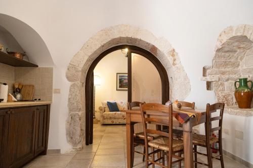 CrispianoMasseria Pilano的厨房以及带桌子和拱门的用餐室。
