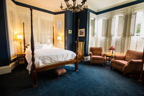 普罗温斯敦Brasswood Inn的一间卧室配有一张床和两把椅子