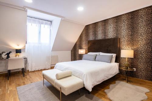 奥维多DE LA GUARDIA SUITE ROSAL的卧室配有一张白色大床和一把椅子