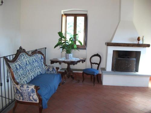 BolanoAgriturismo La Villa的客厅配有椅子和壁炉