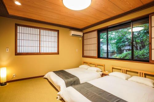 泉佐野Shirakabanoyado - Izumi的带2扇窗户的客房内的2张床